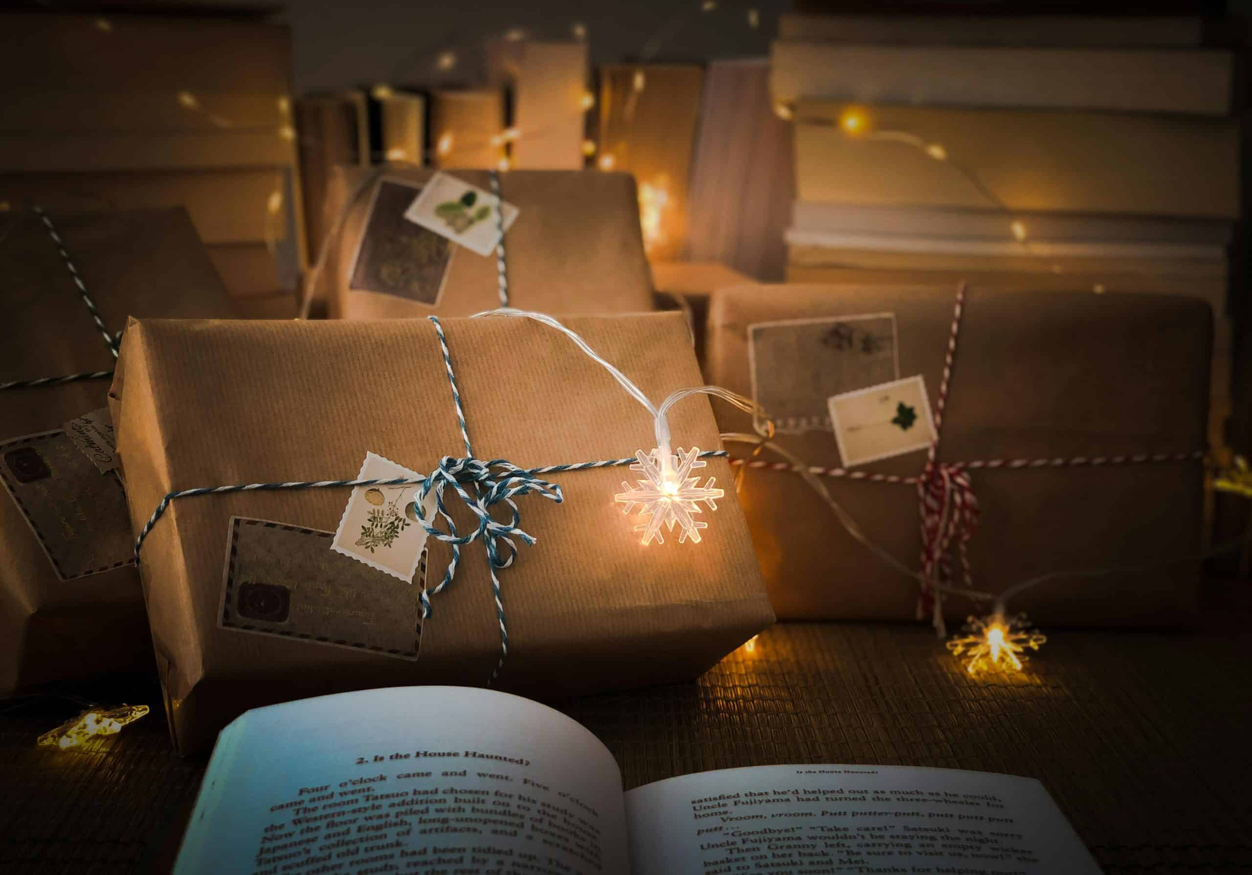 Christmas gift-wrapped packages with writing-themed tags and fairy lights.