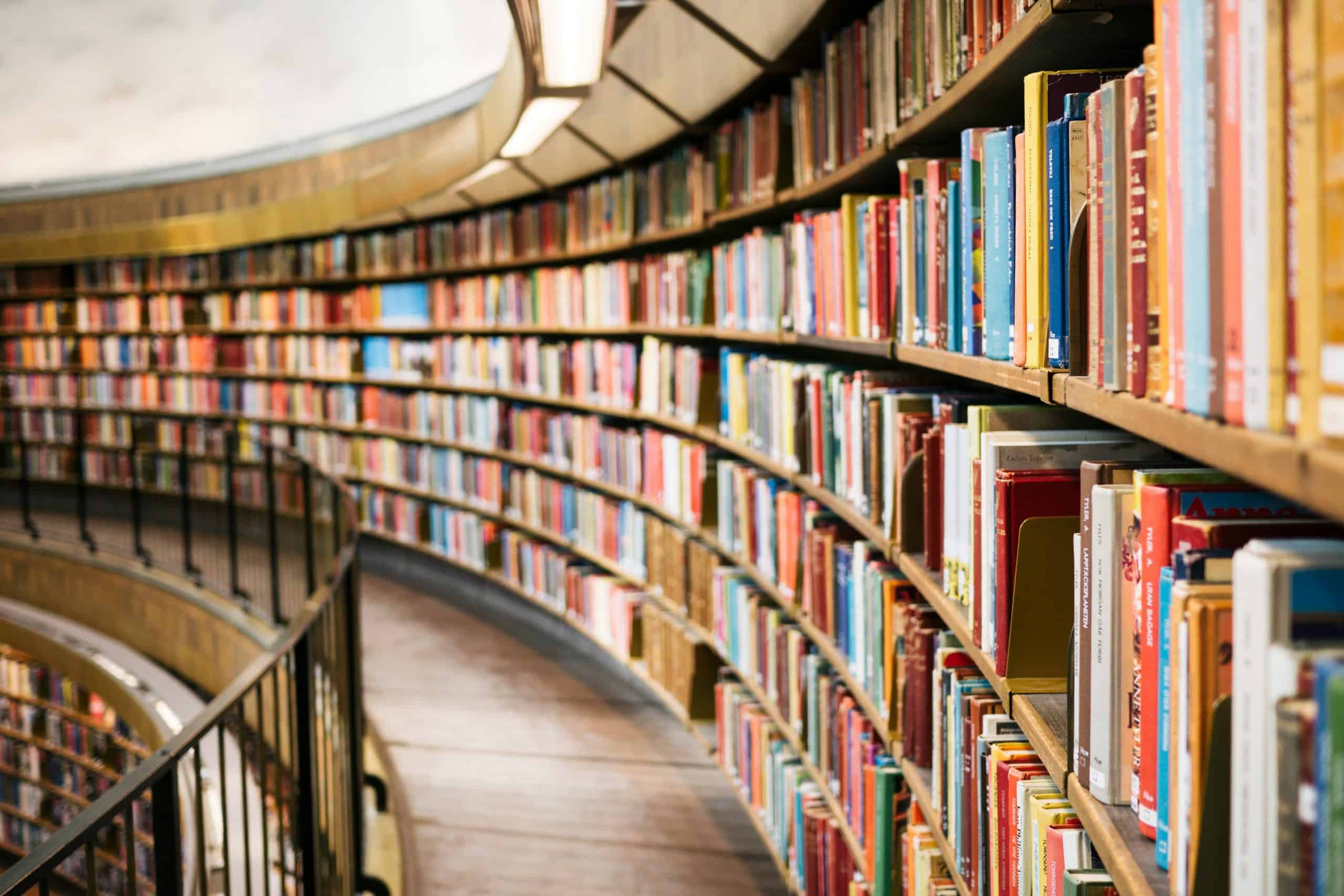 Bookshelves in a library filled with colourful books for creative writing and storytelling ideas.