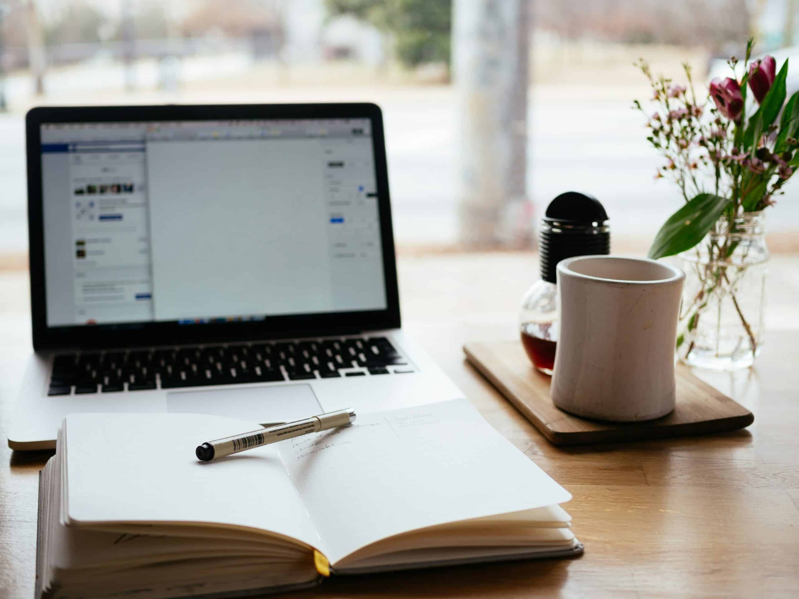 open book in front of a laptop